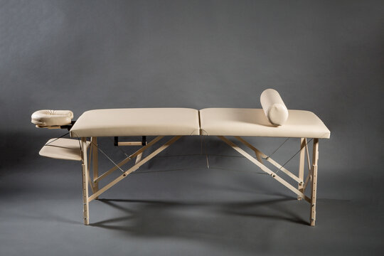 Portable folding massage table for physical therapy treatment room on the dark background