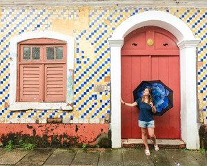 mulher em frente a casa de azulejos no centro histórico de são luis, maranhão  - obrazy, fototapety, plakaty