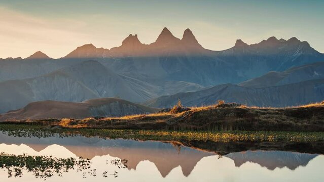 Landscape of sunrise shines over Lac Guichard with Arves massif and lake reflection in autumn at Aiguilles d Arves, French Alps, Savoie, France