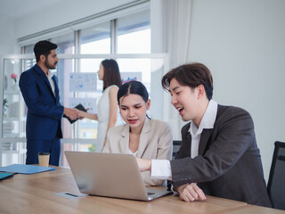 Portrait business team woman pretty girl and man handsome Asian group meeting sitting on desk looking hand holding laptop notebook on table ready for happy working job online sale inside home office
