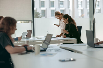 Business people working with laptops in office on colleagues background. Teamwork concept © Kostiantyn