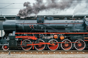 Vintage steam locomotive on a train station.