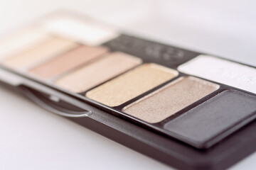 Women's palette with makeup shadows, highlighter base, selective focus