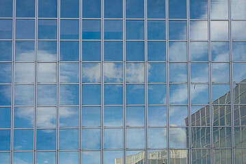 a reflection of the sky on shop windows of a large office building