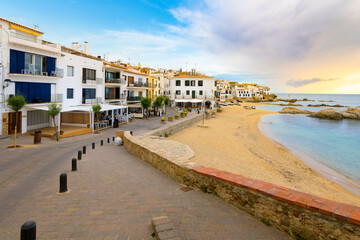 Fototapeta na wymiar Sandy beach in front of the whitewashed fishing village of Calella de Palafrugell along the Costa Brava coastline of the Girona Province, Southern Spain.