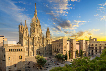 View of the Gothic Barcelona Cathedral of the Holy Cross and Saint Eulalia with surround buildings, plaza and the skyline of Barcelona in view as the sun sets at dusk. - obrazy, fototapety, plakaty