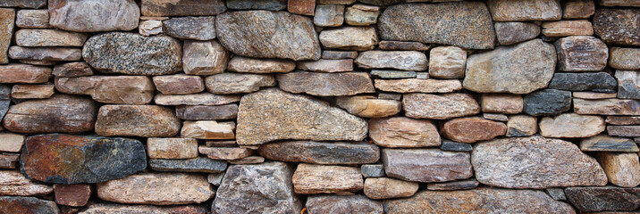 textured stone wall, a symbol of strength and resilience, with natural light casting captivating shadows