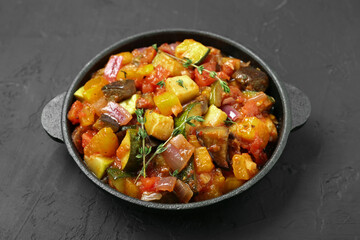 Dish with tasty ratatouille on black table