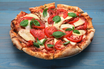 Delicious Caprese pizza on blue wooden table, closeup