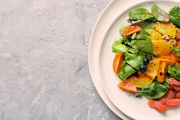 Delicious salad with salmon on gray textured table, top view. Space for text