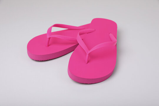 Stylish pink flip flops on white background