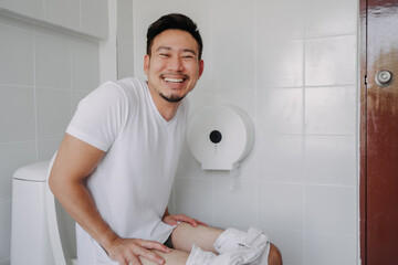 Funny happy face of asian man able to poop after suffer from constipation.