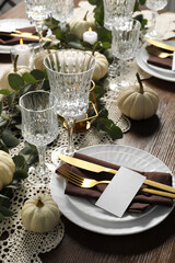 Beautiful autumn table setting. Plates, cutlery, glasses, blank cards and floral decor