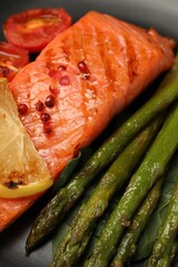 Tasty grilled salmon, lemon and asparagus, closeup