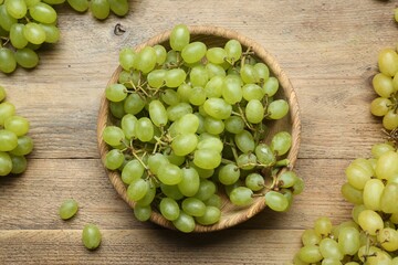 Delicious fresh green grapes on wooden table, flat lay