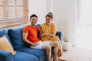 Lovely asian couple lover sit together on the sofa in the warm house.