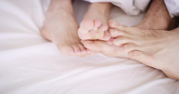 Couple, feet and together for cuddle on bed, sleep or relax in peace for morning in room. Man, woman or love in romance for dating, marriage or relationship for bonding, rest or comfort on weekend