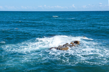 Large ocean big power wave crashing onto a rock beach  