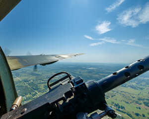 view from right gun turret of WWII bomber in flight with right wing visible