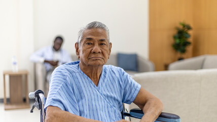 Old man sitting on a wheelchair in a health care office with happy face