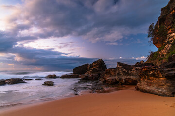 Sunrise seascape with low clouds and waves