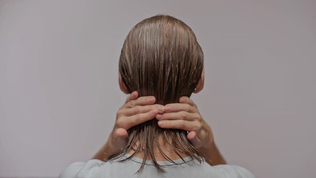 woman applying conditioner to short hair. Back view