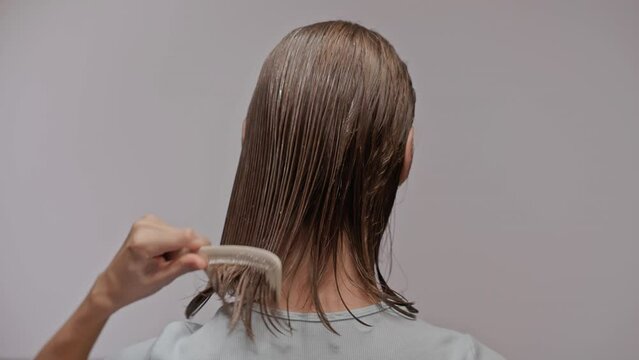 woman applying conditioner to short hair. Back view