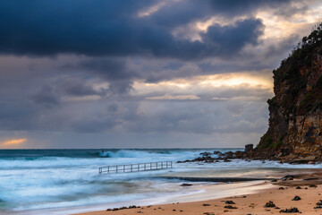 Wet weather sunrise with choppy waves at the seaside