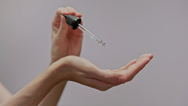 woman hand applies moisturizing serum from a pipette. Skin care concept