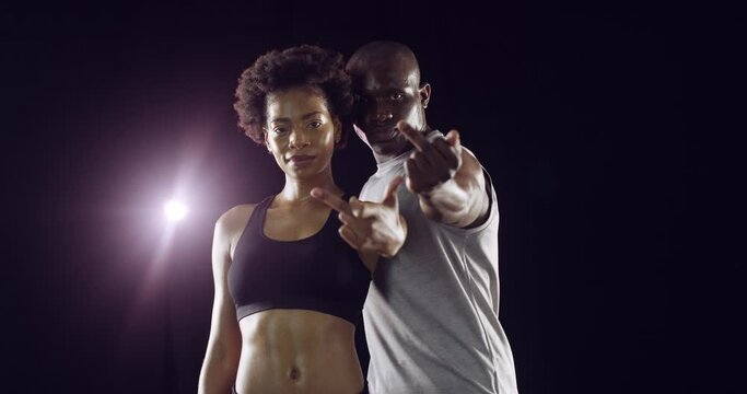 Hand, rude and middle finger for fitness with a black couple in studio on a dark background for health. Portrait, offence or disrespect with a man and woman during an exercise workout or training