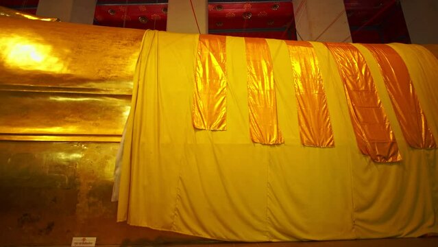 Robes, a large piece of cloth, were hung on the reclining Buddha..The signature of this temple is the big beautiful reclining Buddha .at Wat Phra Non Chak Si Worawihan Sing Buri Thailand.
