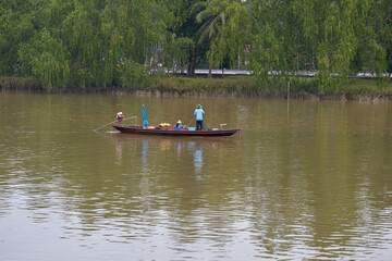 The fisherman throwing fishing net on long-tail boat