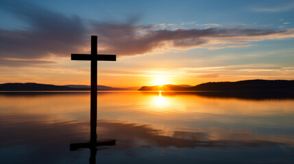 Fototapeta na wymiar Sunrise or sunset over a calm body of water, with a cross silhouette in the foreground, symbolizing new beginnings and faith, copy space.