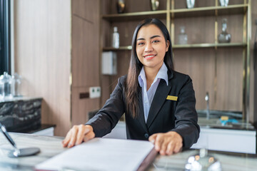 Beautiful asian hotel receptionist in  uniforms at desk in lobby Friendly and welcome staff in hotel reception counter.