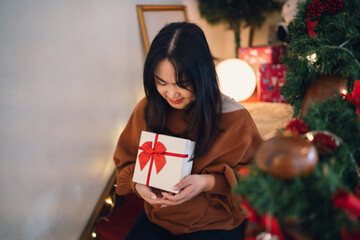 Happy asian woman hugging gift box. Receiving Christmas gift. Cheerful girl with Xmas present or open box xmas new year birthday gift.