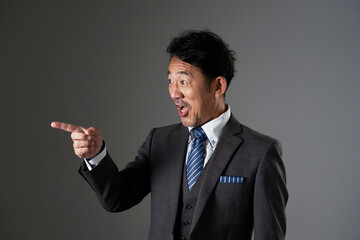左側を指差すビジネスマン　黒背景