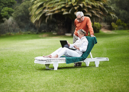 Love, relax and senior couple with laptop in garden for internet, search or communication while bonding. Social media, computer and old people chilling in backyard with online streaming subscription - Powered by Adobe