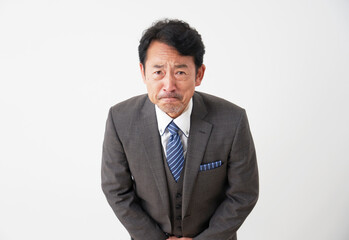 お辞儀をして謝る中年のビジネスマン　白背景