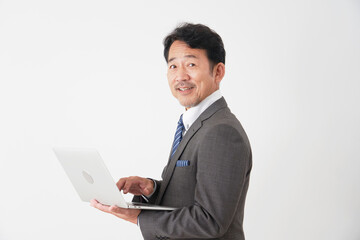 ノートパソコンを使う中年のビジネスマン　白背景