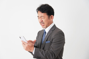 スマートフォンを見て悲しむ中年のビジネスマン　白背景