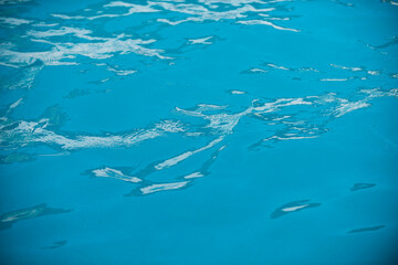 Ripped water in swimming pool. Surface of blue swimming pool, background of water.