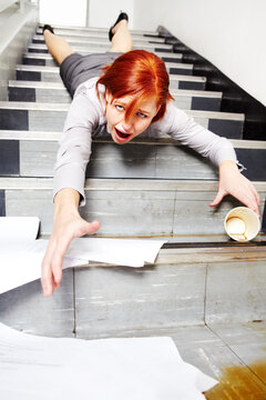 Woman, falling down and stairs for injury, accident and wow with coffee, documents or paperwork in building. Business, person or employee slipping on steps at work or office with paper, cup and shock