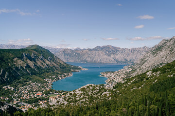 Fototapeta na wymiar Valley of the Bay of Kotor surrounded by high mountains in bright sunlight. Montenegro