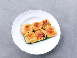 Banana choco. a group of bread that has a crispy layer of skin. Banana balls. Cake with banana and chocolate filling on plate over gray background