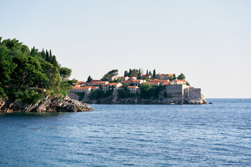 Fototapeta na wymiar View from the sea to the island of Sveti Stefan behind the green cape. Montenegro