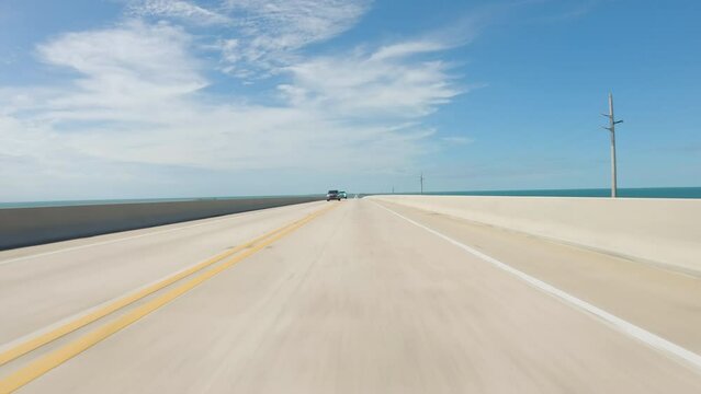 Driving a car going down on Seven Mile Bridge, sunny day in Florida Keys. POV