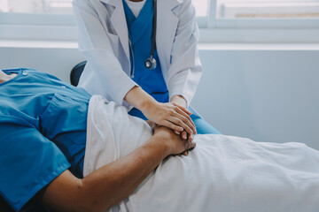 Women Asian doctors hold the patient hand and encourage and provide medical advice While checking...