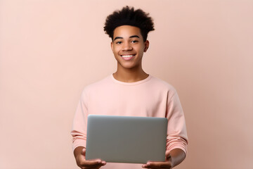 Happy smiling African American teenager student holding laptop using computer technology presenting e learning, online education websites isolated on light beige background