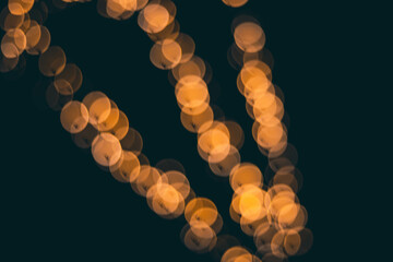 Blurred bokeh lights on a black background, sparkling light particles in a dark environment