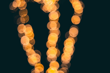 Blurred bokeh lights on a black background, sparkling light particles in a dark environment